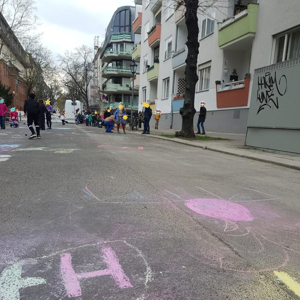 Kreide Bilder auf der Straße - im Hintergrund spielende Kinder